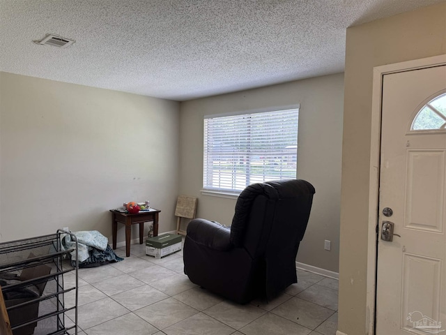 entryway with light tile patterned floors and a textured ceiling