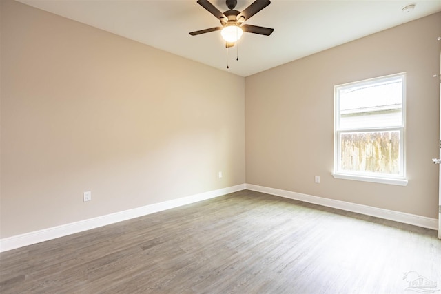 unfurnished room with ceiling fan, baseboards, and wood finished floors