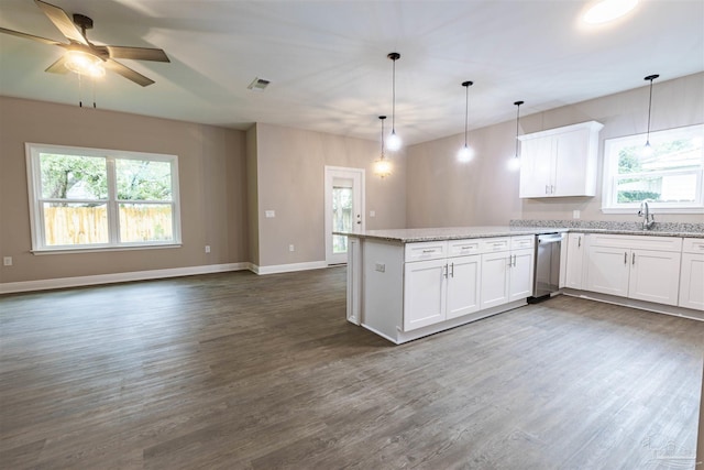 kitchen with a peninsula, dark wood-type flooring, white cabinetry, and light stone countertops