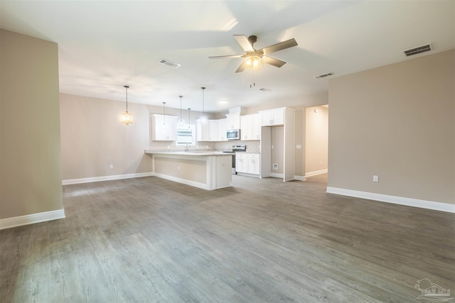 kitchen featuring ceiling fan, wood finished floors, visible vents, open floor plan, and appliances with stainless steel finishes