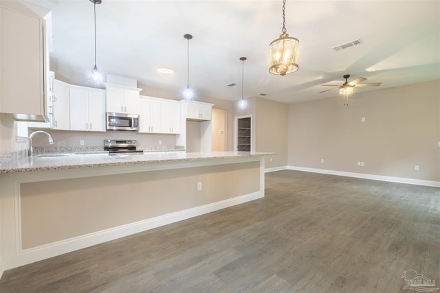 kitchen with ceiling fan, wood finished floors, a sink, white cabinetry, and appliances with stainless steel finishes