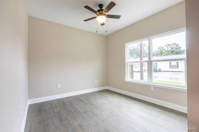 unfurnished room featuring ceiling fan, baseboards, and wood finished floors