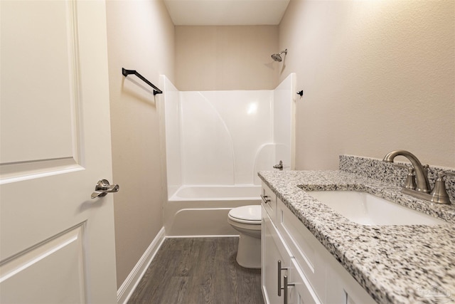 full bath featuring bathtub / shower combination, toilet, wood finished floors, vanity, and baseboards