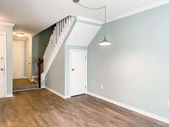 interior space with wood finished floors, crown molding, and stairs