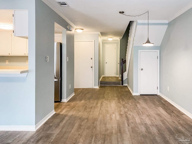 hall with visible vents, crown molding, baseboards, and wood finished floors