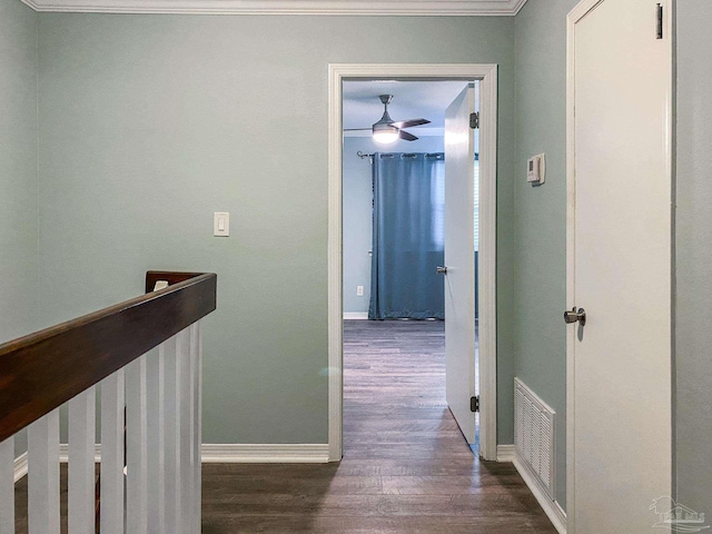 hall with an upstairs landing, wood finished floors, visible vents, and baseboards