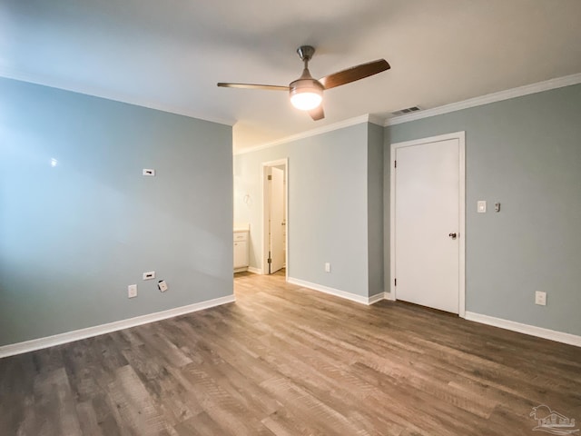 spare room featuring baseboards, crown molding, visible vents, and wood finished floors