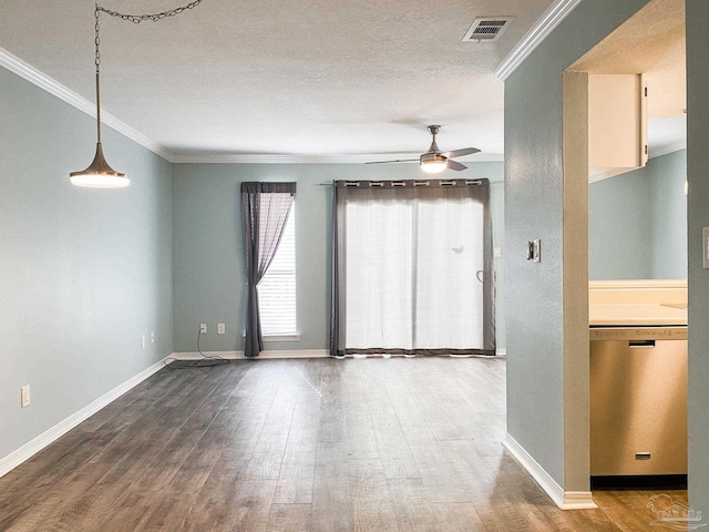 spare room with baseboards, visible vents, wood finished floors, and ornamental molding