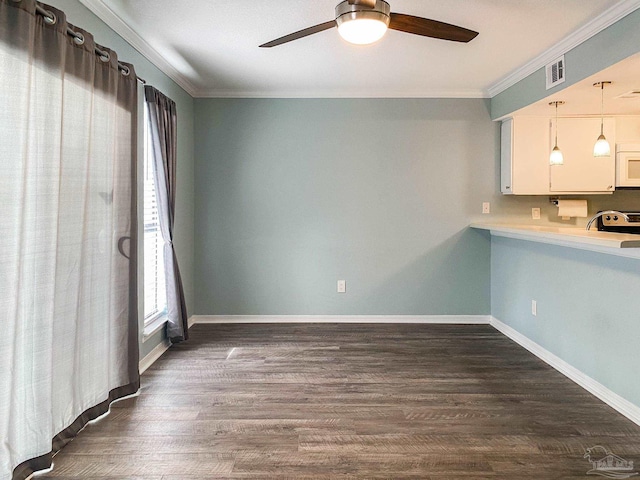 interior space with white microwave, visible vents, ornamental molding, and dark wood finished floors