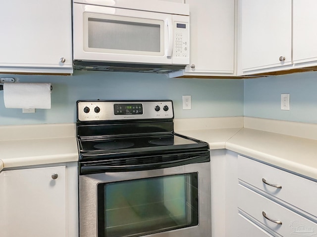 kitchen featuring white microwave, white cabinetry, stainless steel electric stove, and light countertops