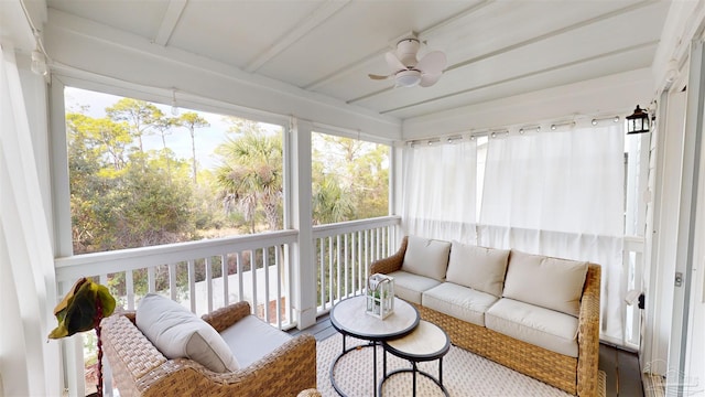 sunroom / solarium featuring beam ceiling and ceiling fan