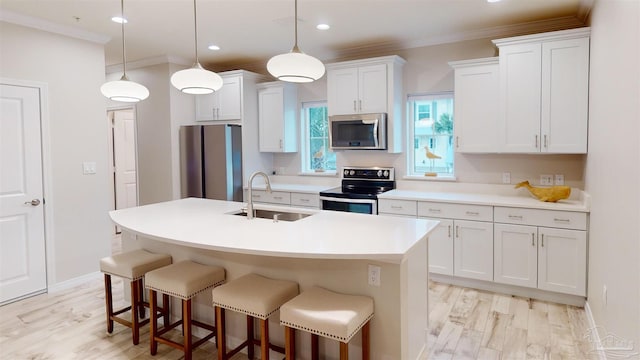 kitchen featuring white cabinetry, sink, pendant lighting, and stainless steel appliances