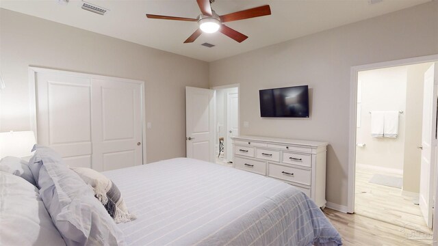 bedroom featuring ceiling fan, ensuite bathroom, light hardwood / wood-style floors, and a closet