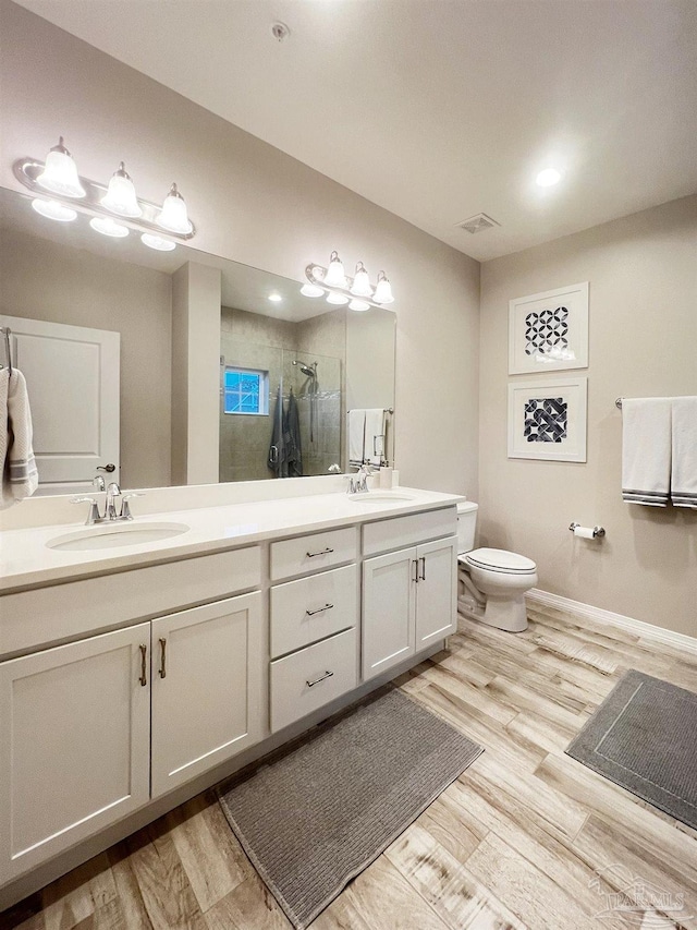 bathroom with vanity, wood-type flooring, a shower with door, and toilet