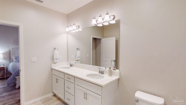 bathroom featuring vanity, hardwood / wood-style flooring, and toilet