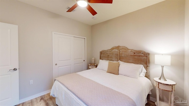 bedroom featuring ceiling fan, light hardwood / wood-style floors, and a closet