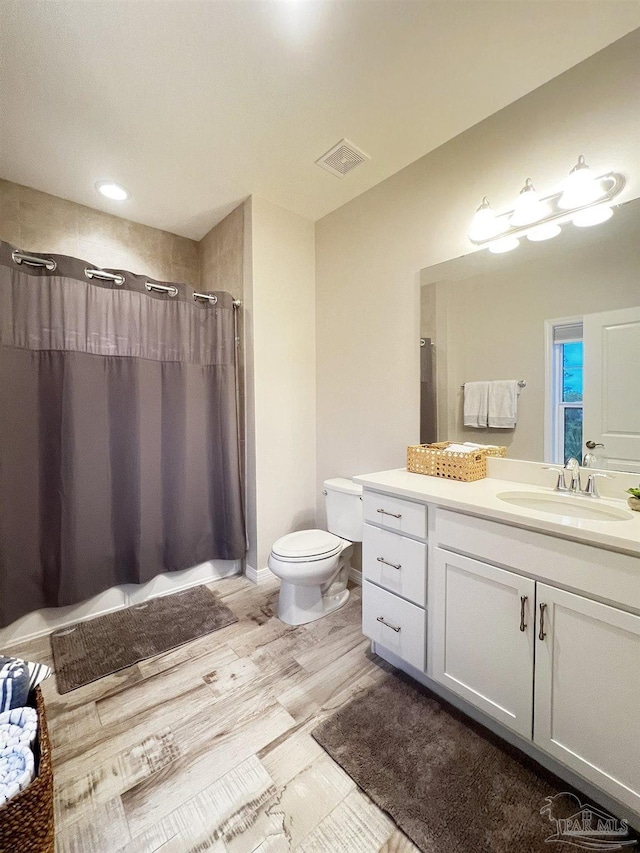 bathroom with a shower with curtain, vanity, toilet, and wood-type flooring