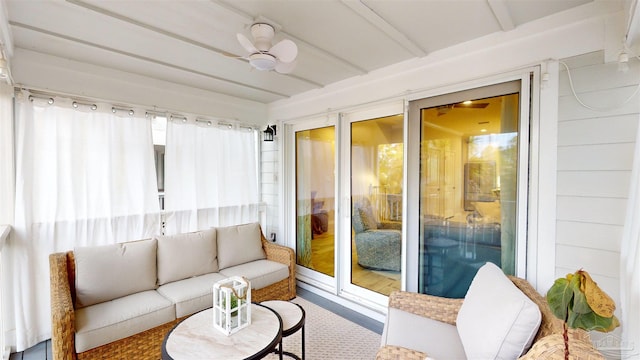 sunroom / solarium featuring beam ceiling and ceiling fan