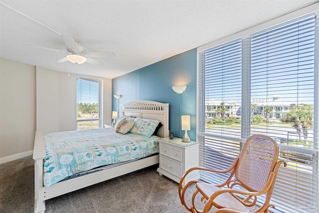 carpeted bedroom featuring ceiling fan and a textured ceiling