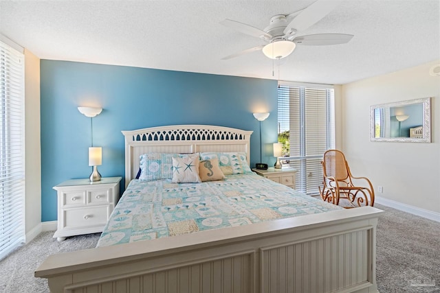 carpeted bedroom featuring ceiling fan and a textured ceiling