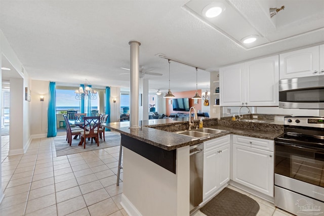 kitchen with kitchen peninsula, white cabinets, stainless steel appliances, and sink