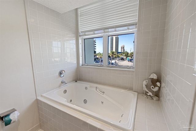 bathroom featuring a textured ceiling and tiled bath