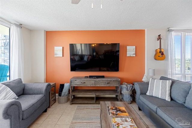 tiled living room with ceiling fan and a textured ceiling