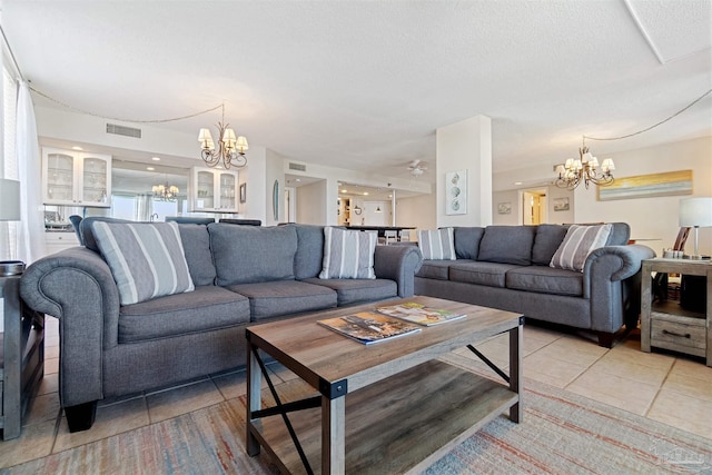 tiled living room featuring a notable chandelier and a textured ceiling