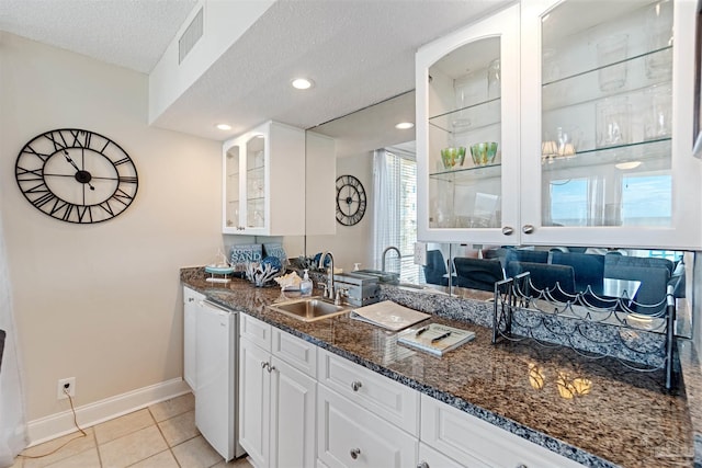 kitchen with white cabinetry, dark stone countertops, sink, and a textured ceiling