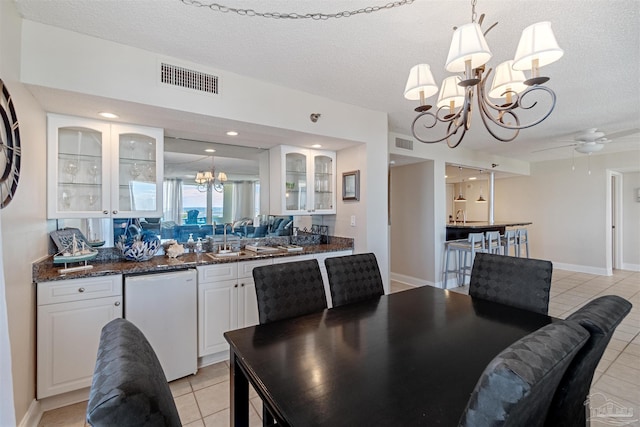 dining space featuring a textured ceiling, ceiling fan with notable chandelier, and light tile patterned floors