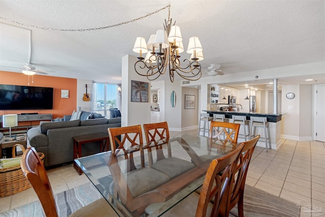 dining space featuring a textured ceiling, light tile patterned flooring, and ceiling fan with notable chandelier