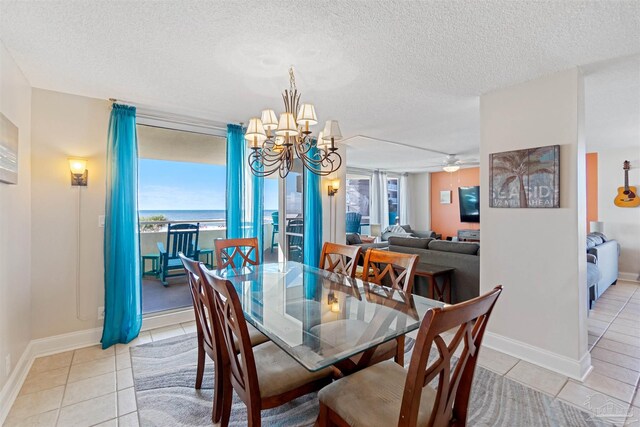 tiled dining space featuring a textured ceiling and ceiling fan with notable chandelier