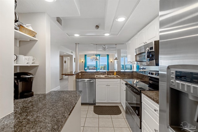 kitchen with kitchen peninsula, white cabinetry, sink, decorative light fixtures, and stainless steel appliances