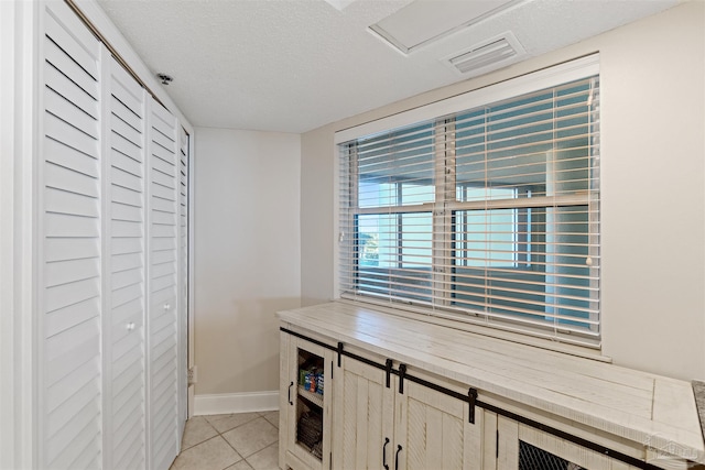 interior space featuring light tile patterned flooring and a textured ceiling