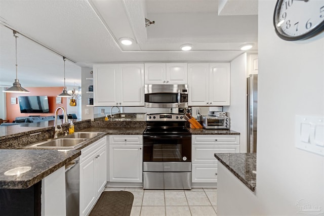 kitchen featuring sink, pendant lighting, white cabinetry, light tile patterned floors, and appliances with stainless steel finishes