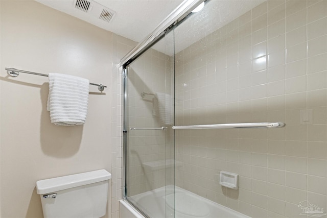 bathroom featuring toilet and enclosed tub / shower combo