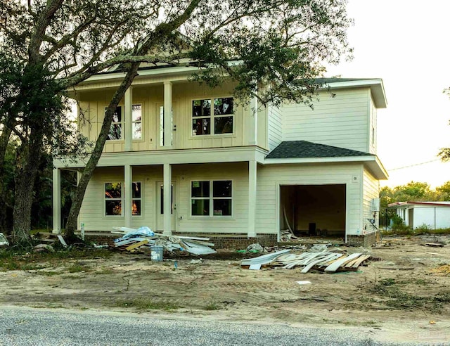 rear view of property with board and batten siding and a garage