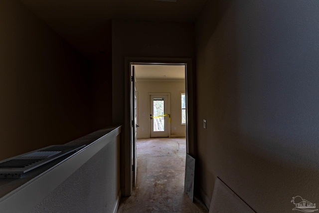 corridor with unfinished concrete floors and ornamental molding