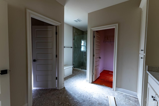 bathroom featuring vanity, baseboards, visible vents, a stall shower, and a spacious closet