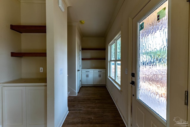 doorway with dark wood finished floors and baseboards