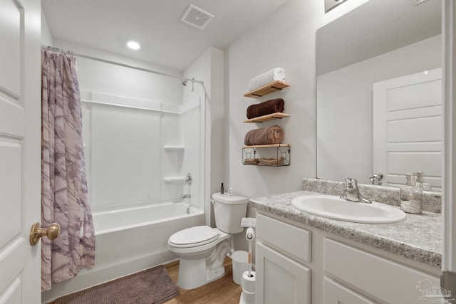 bathroom with visible vents, toilet, wood finished floors, shower / tub combo with curtain, and vanity