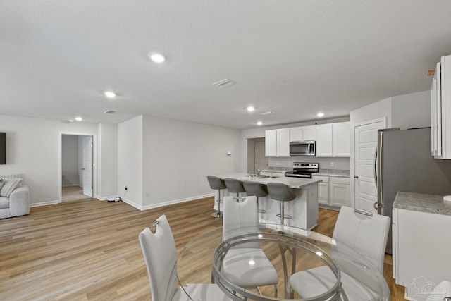 dining area featuring recessed lighting, light wood-type flooring, visible vents, and baseboards