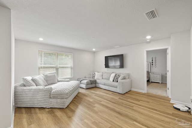 living room with light wood finished floors, visible vents, and recessed lighting