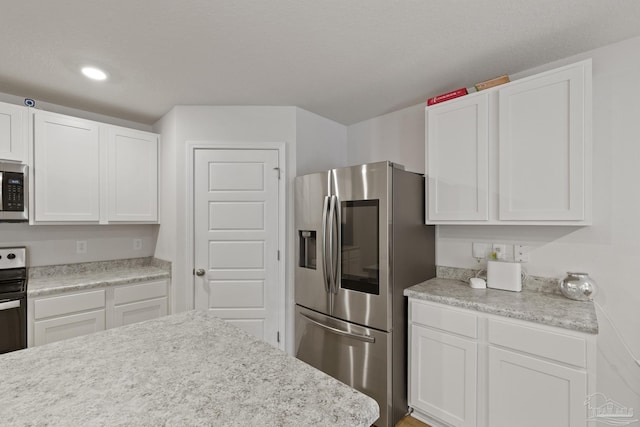 kitchen featuring light countertops, appliances with stainless steel finishes, recessed lighting, and white cabinets