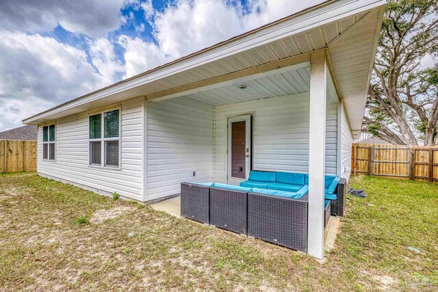 rear view of house featuring a fenced backyard, outdoor lounge area, and a yard