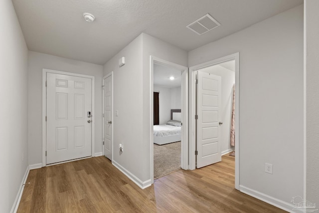 foyer with visible vents, baseboards, and wood finished floors