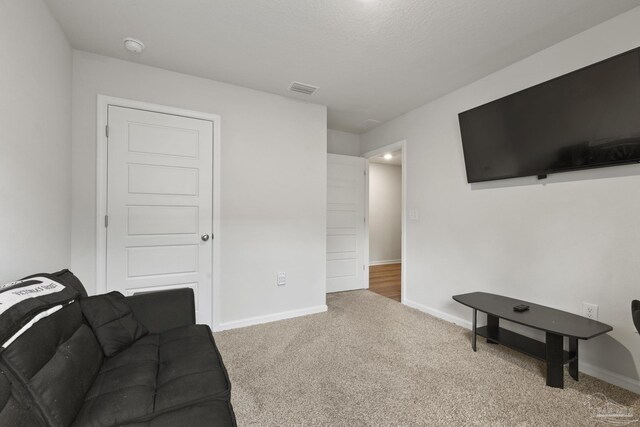 carpeted living room featuring visible vents and baseboards