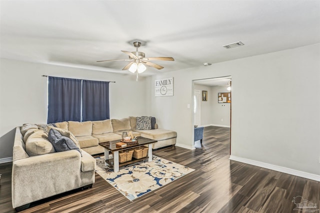 living room with baseboards, visible vents, ceiling fan, and dark wood finished floors