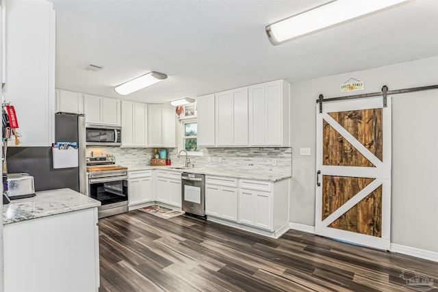 kitchen featuring dark wood-style flooring, appliances with stainless steel finishes, tasteful backsplash, and a sink