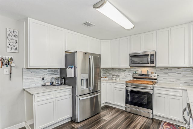 kitchen with dark wood-type flooring, visible vents, white cabinetry, and stainless steel appliances